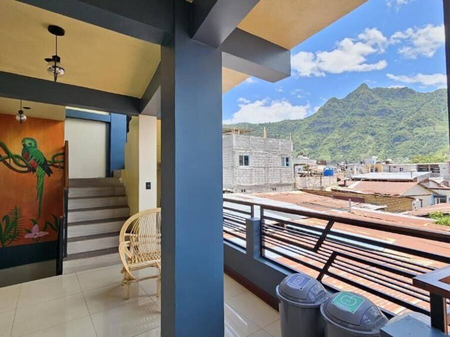 Eine Treppe führt zu einem Balkon mit Blick auf eine gebirgige Landschaft.