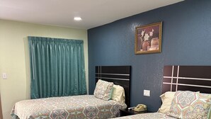 Ein Hotelzimmer mit zwei Betten, einem Nachttisch, einem Telefon und einem Bild an der Wand.