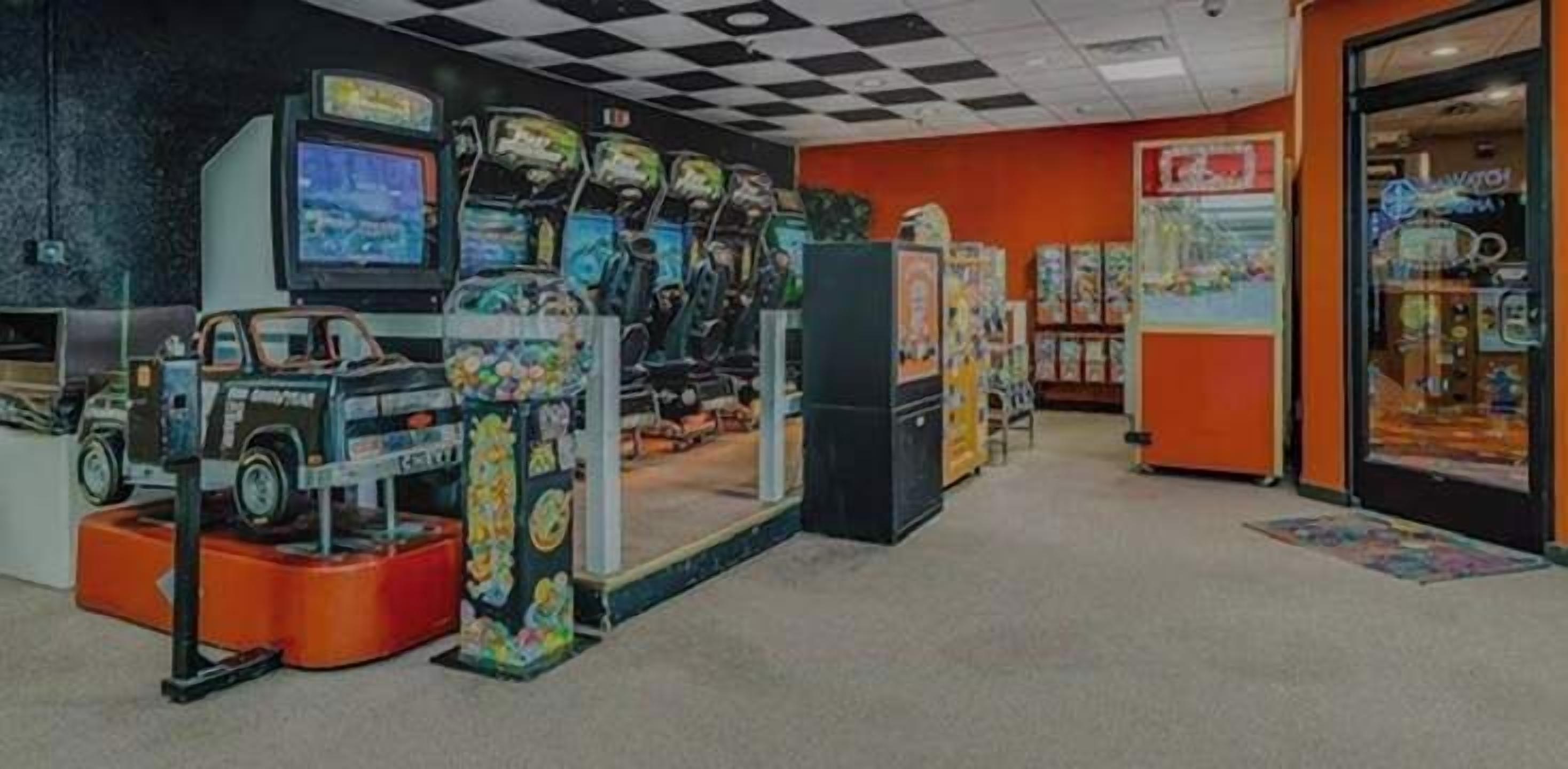 Ein Spielhallenparadies mit zahlreichen Spielautomaten, einem Fernseher und diversen Spielzeugen.