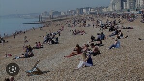 Una playa concurrida con gente tomando el sol y relajándose.