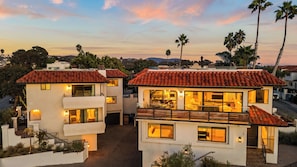 A two-story house with a balcony, a patio, and a view of the surrounding neighborhood.