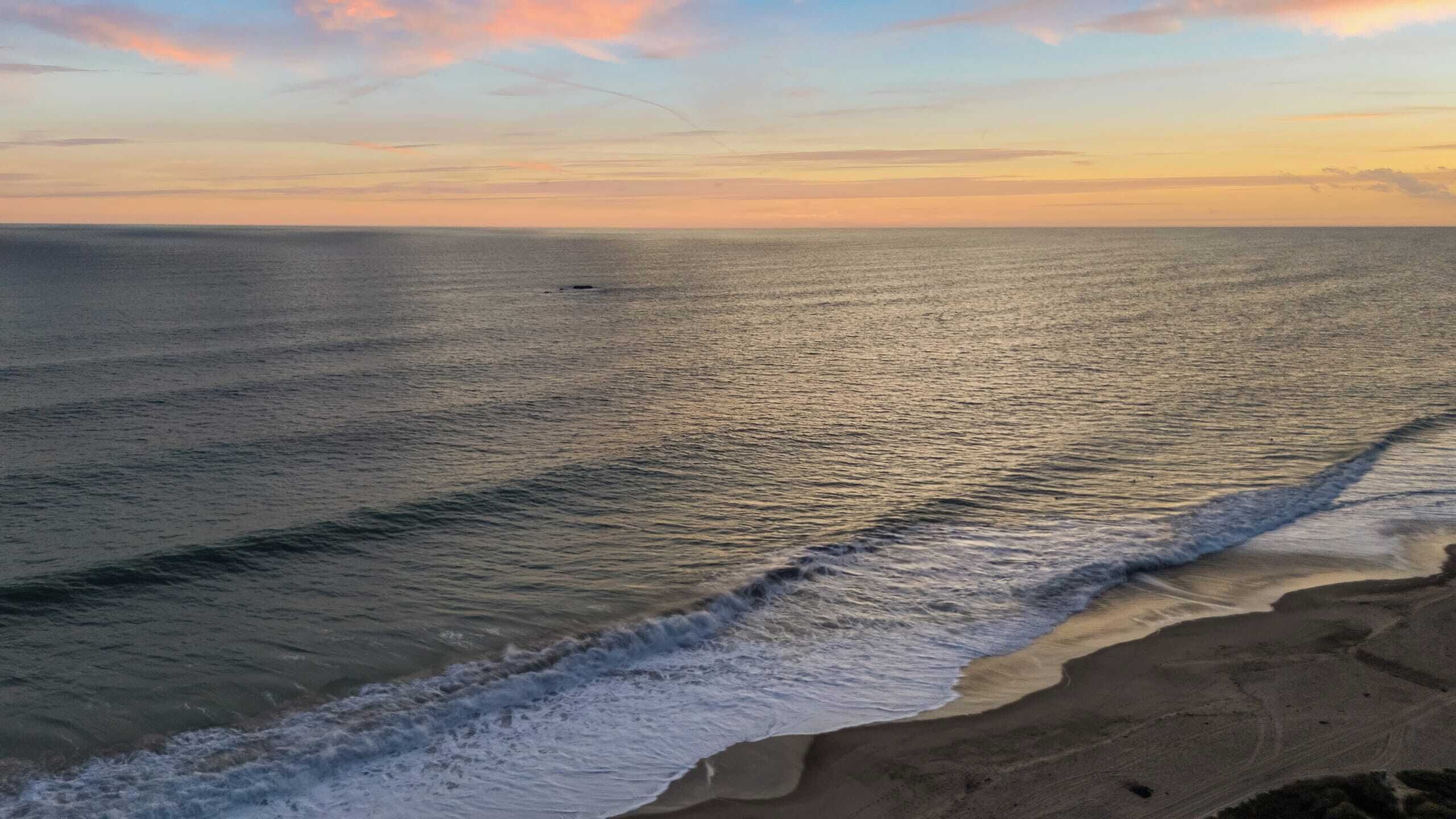 Een strand met golven die de kust naderen.