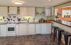 A kitchen with white cabinets, a stove, a sink, and a coffee maker. - 3 bedroom beautiful home in Vissefjärda (Vissefjärda)