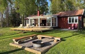 A house with a deck, outdoor seating, and a fire pit. - 3 bedroom amazing home in Vissefjärda (Vissefjärda)