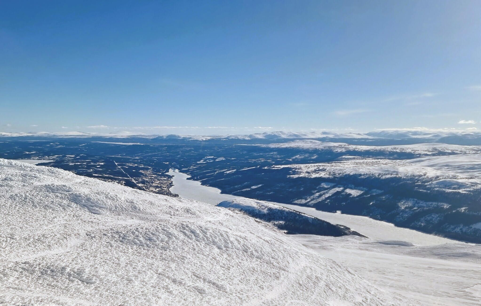 A snow-covered mountainous landscape with a clear sky.