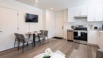 A modern kitchen with white cabinets, a built-in oven, and a dishwasher.