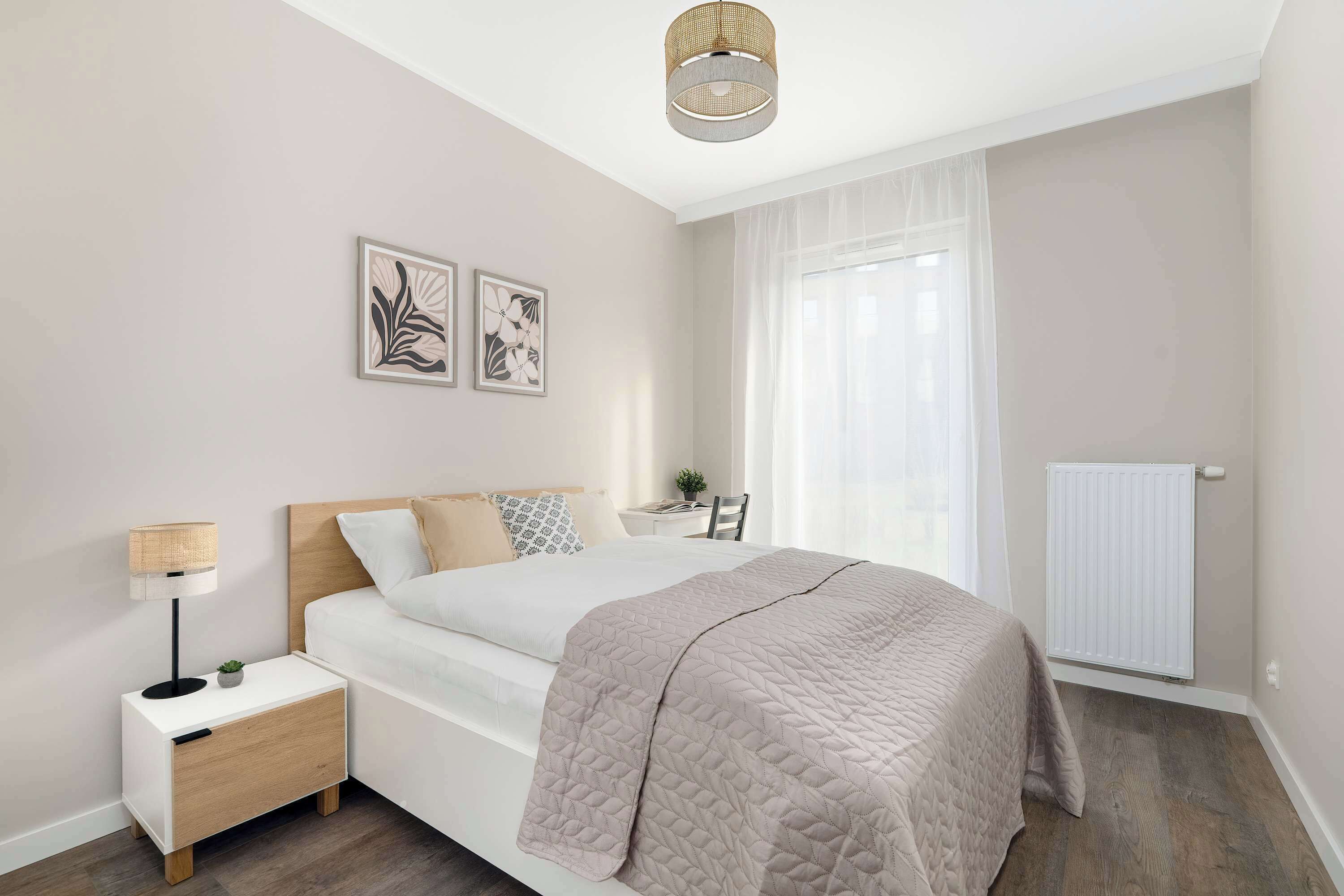 A serene bedroom with a double bed, bedside lamps, and soft bedding. The room is decorated in gentle neutrals for a peaceful atmosphere.