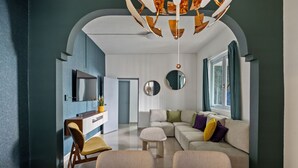 A modern living room with a sectional sofa, a dining table, and a TV mounted on the wall. - Ocean Park 3BD+2BA Pool Walk to beach @Portocafe (San Juan)