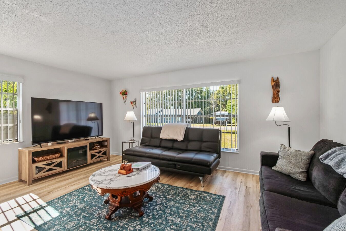 A modern living room with a flat-screen TV, leather sofa, and a coffee table.