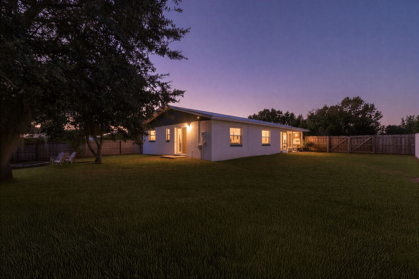 Une maison de plain-pied avec une pelouse bien entretenue et une clôture en bois.
