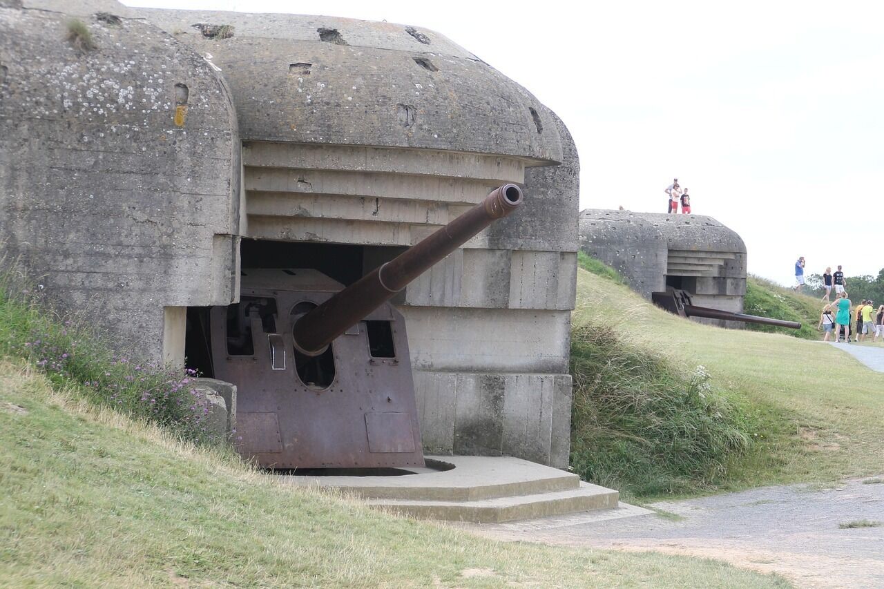 A large concrete bunker with a cannon protruding from the front, surrounded by grassy terrain.