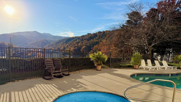 A pool area with a view of mountains, lounge chairs, and a fence. - 10 Minutes Walk To Anakeesta, 2BR/2BA, Sleeps 6, Elevator on Premises (Gatlinburg)