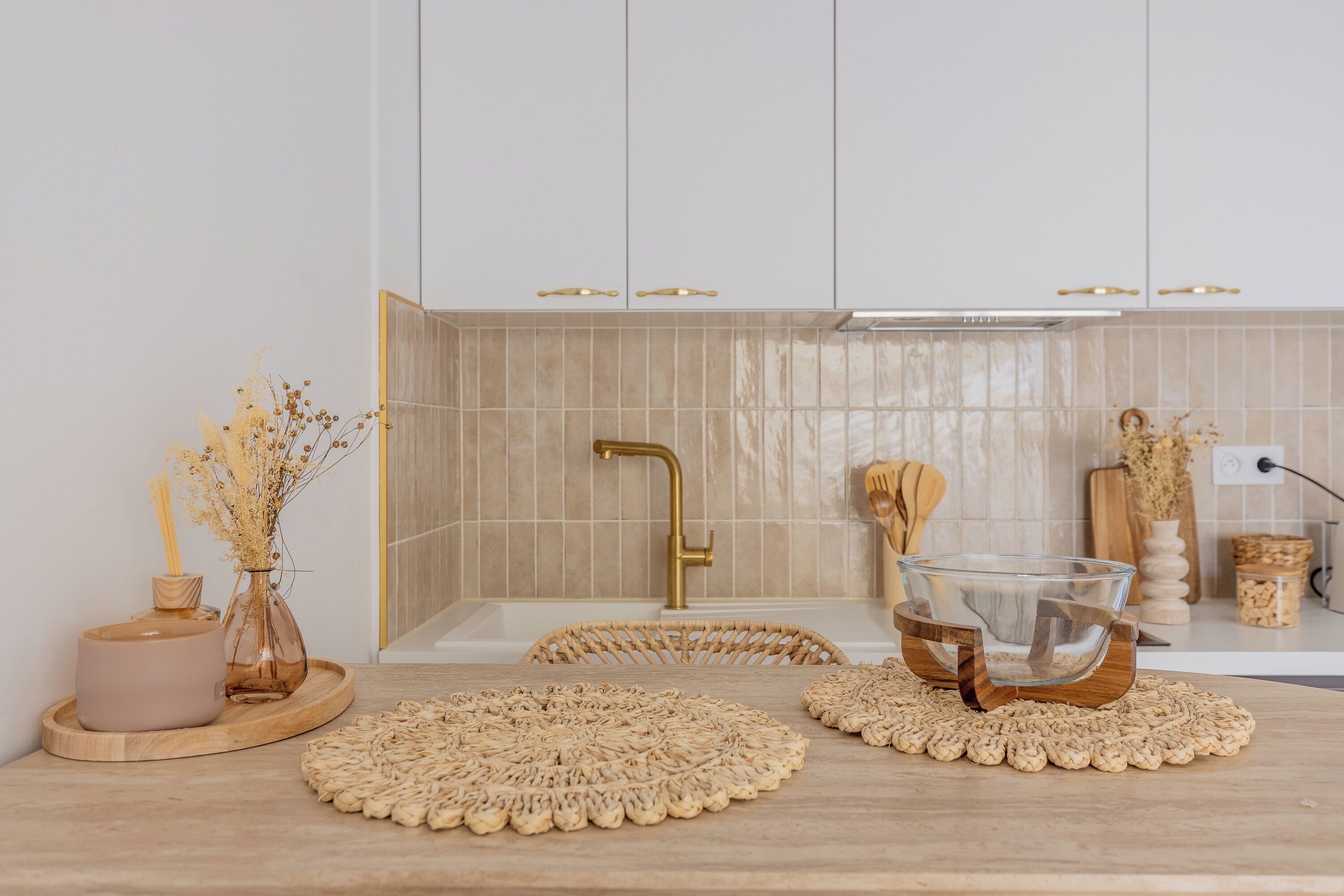 A kitchen with a wooden countertop, a glass bowl, and woven placemats.