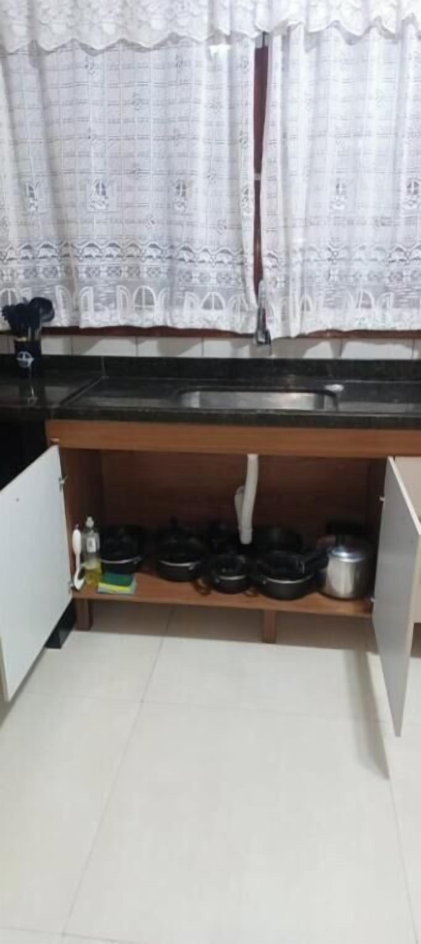 A kitchen with a wooden countertop, a sink, and a cabinet below.
