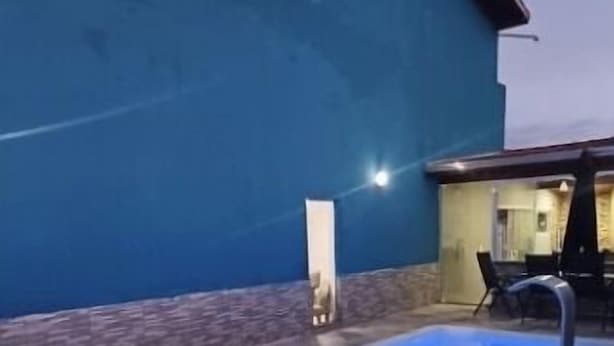Ein Pool mit blauer Innenausstattung, umgeben von einer gefliesten Terrasse.