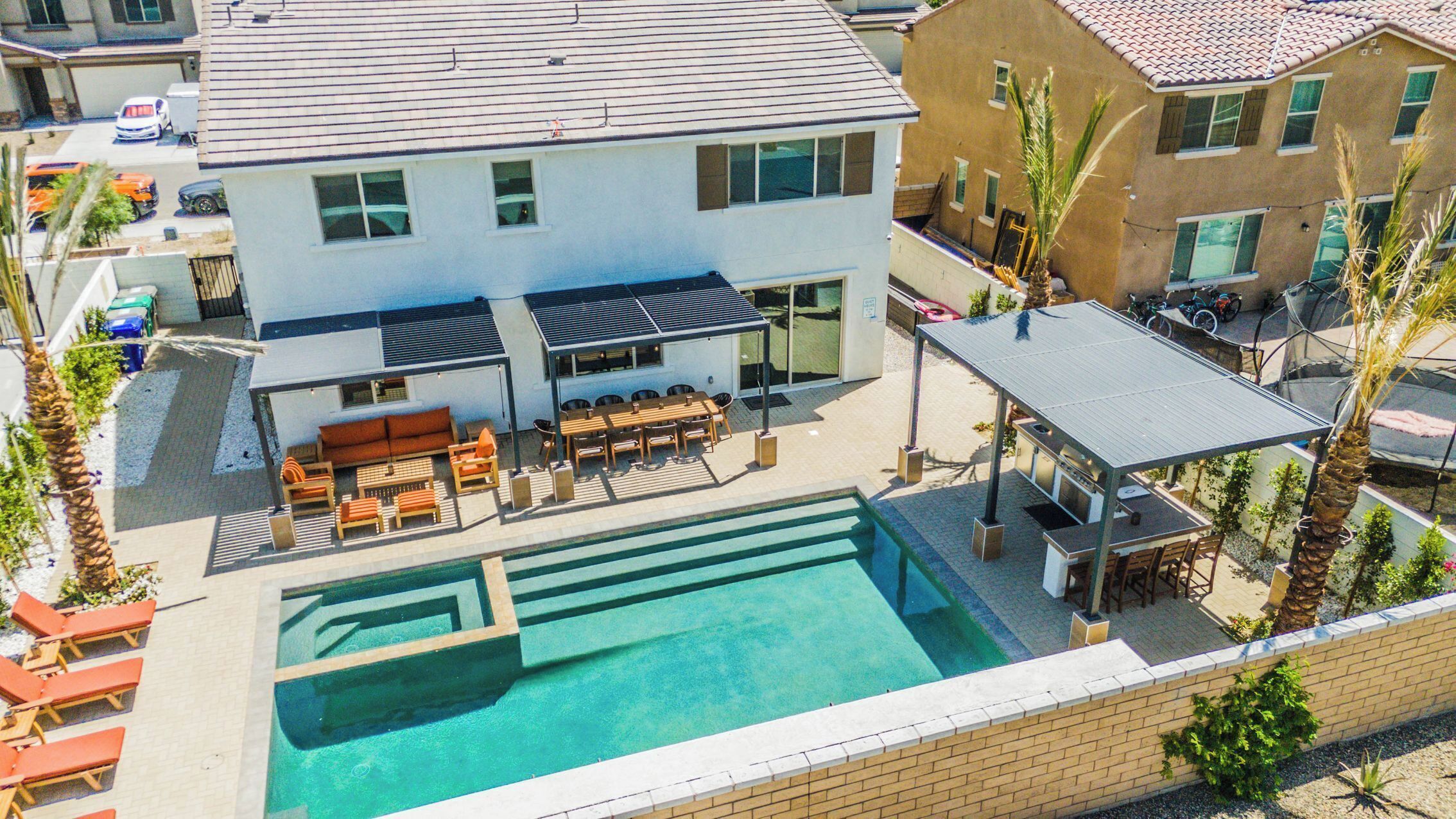 Una propiedad residencial con piscina, mobiliario de exterior y terraza cubierta.