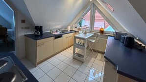 Cocina compacta con comedor, ventana con vistas y radiador.