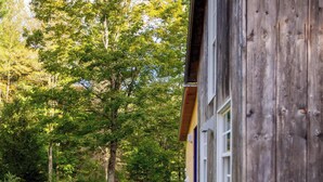 Een houten gebouw met een grindpad dat naar een deur leidt.
