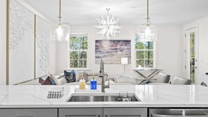 A modern kitchen with a marble countertop, stainless steel appliances, and pendant lighting. - Bright 30A Two-suite Condo Balcony Views, Pool, Hot Tub, Near Gulf Place Emerald Oasis by Avantstay (Santa Rosa Beach)