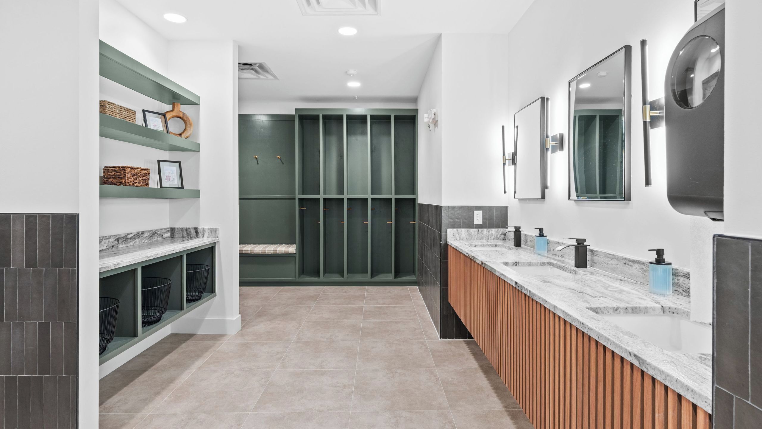 A modern bathroom with a long vanity, multiple sinks, and a walk-in shower.
