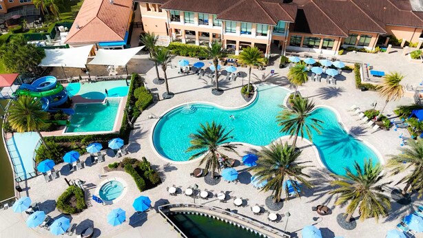 Een resort met meerdere zwembaden, ontspanningszones en palmbomen.