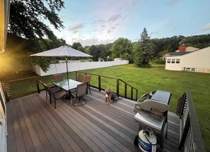 A deck with a grill, outdoor furniture, and a dog. - Pet-Friendly Saratoga Home | Mins from Downtown (Saratoga Springs)