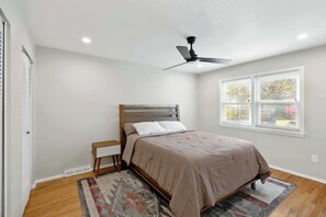 A bedroom with a bed, a ceiling fan, a window with blinds, and a small bedside table. - Pet-Friendly Saratoga Home | Mins from Downtown (Saratoga Springs)