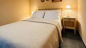 A hotel room with a bed, a nightstand with a lamp, and two wall decorations. - Casa Terras do Douro (Armamar)