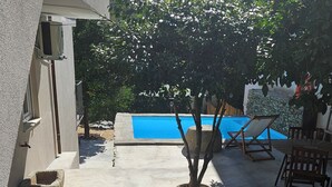 A courtyard with a swimming pool, stone seating, and a staircase leading to a building. - Casa Terras do Douro (Armamar)