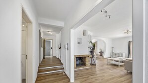 Ein großzügiger Wohnbereich mit Kamin, Holzboden und einem modernen Sofa.
