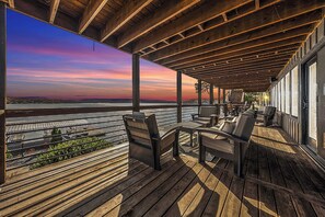 Eine Holzterrasse mit Sitzgelegenheiten und Blick auf einen Fluss.
