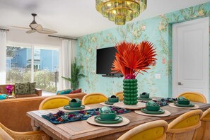 A dining area with a wooden table set for four, surrounded by yellow chairs. - 6BR Reunion Villa w/ Pool, Cinema & Games (Kissimmee)