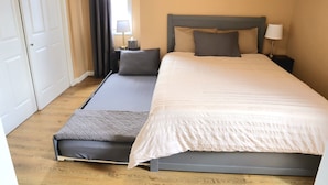 A neatly arranged bedroom with a bed, bedside tables, and a window with curtains.