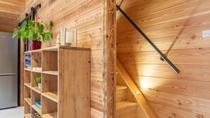 A wooden interior with a staircase and a wooden shelving unit.