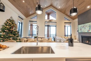 Una cocina moderna con una isla grande, un árbol de Navidad y una chimenea.