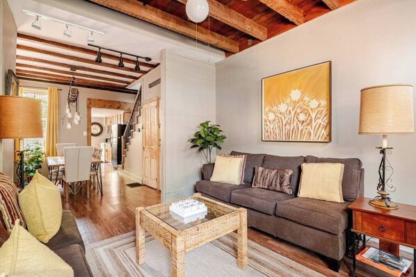 A living room with a sofa, coffee table, and lamp. There is a staircase leading to another room.