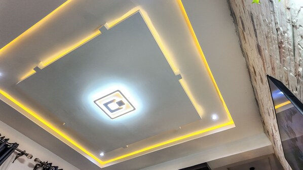 A modern ceiling with recessed lighting and a central light fixture.