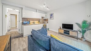 A modern apartment with a kitchen, living room, and a TV. - College Lane Apartment, Bury St Edmunds (Bury St Edmunds)