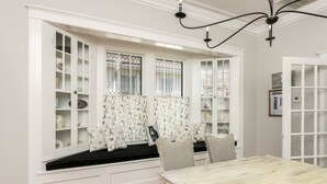 Une pièce dotée d’une banquette intégrée avec des placards de rangement, d’une table en bois et d’un lustre.