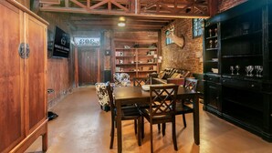 Una habitación acogedora con una mesa de madera, un sofá de cuero y una estantería.