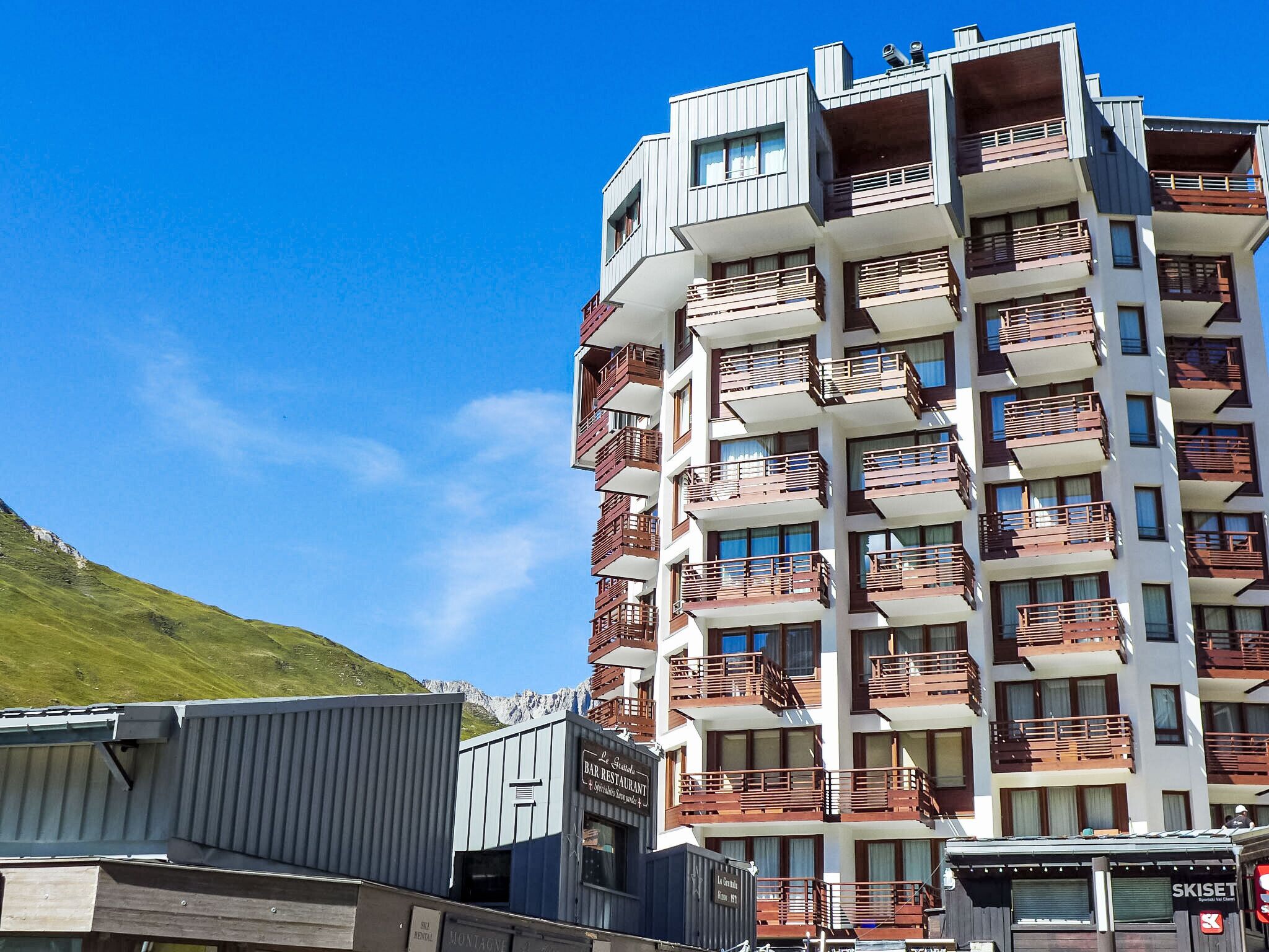 Et hotel med flere etager, altaner, en restaurant og et skilejemålstiltavle.