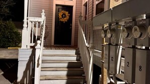 A house with a porch, a staircase leading to the front door, and a utility meter on the side. - Wild Western Property (Huntsville)