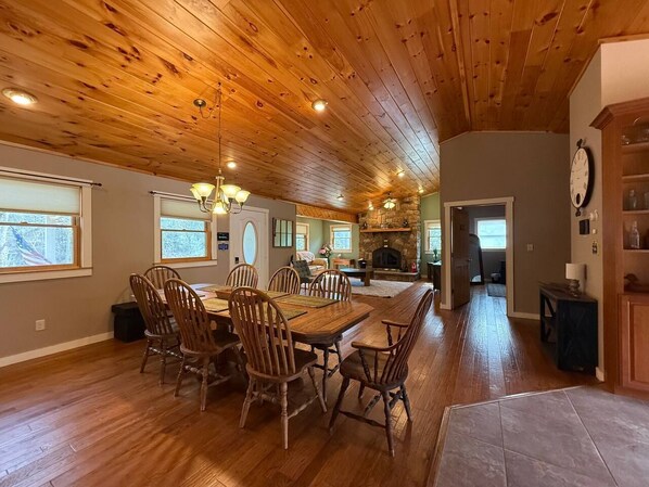 A spacious dining area with wooden flooring and a high ceiling.