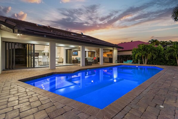 Uma casa moderna com piscina, janelas amplas e área de varanda.