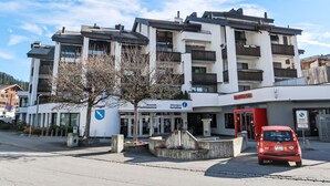 A multi-story building with a modern architectural design, featuring balconies and large windows. - Center Communal D1 by Interhome (Laax)