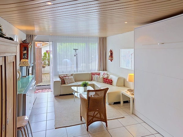A modern living room with a sofa, a dining table, and a chair.