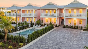 Ein Hotel mit Pool, mehreren Balkonen und einem gepflegten Garten.
