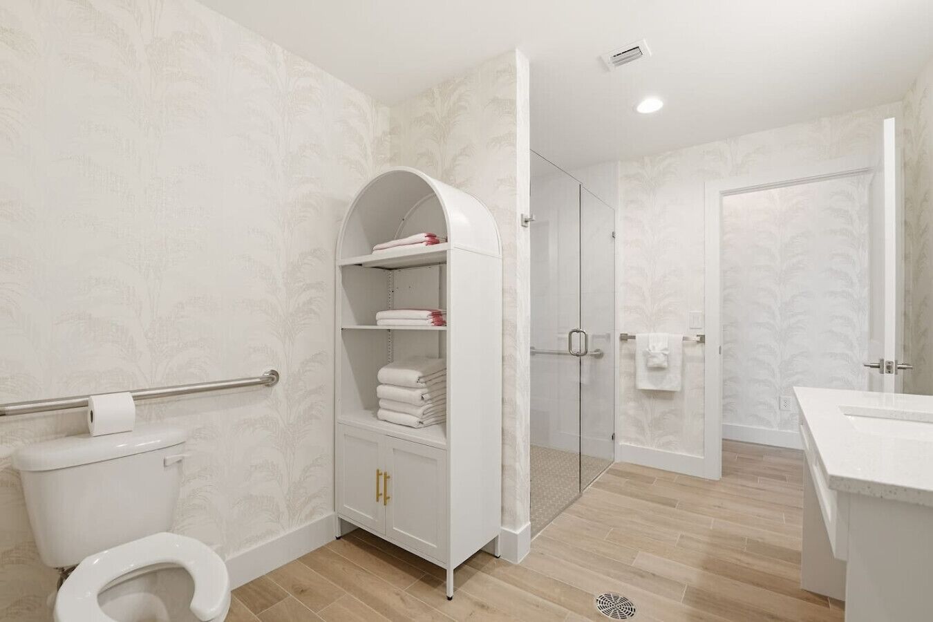 Une salle de bain comprenant des toilettes, une douche et un meuble-lavabo avec un miroir.