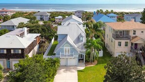 Un área residencial costera con casas, vista despejada del océano y un césped bien cuidado.