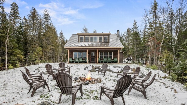Un chalet doté d’un foyer extérieur et de sièges pour profiter de l’extérieur.
